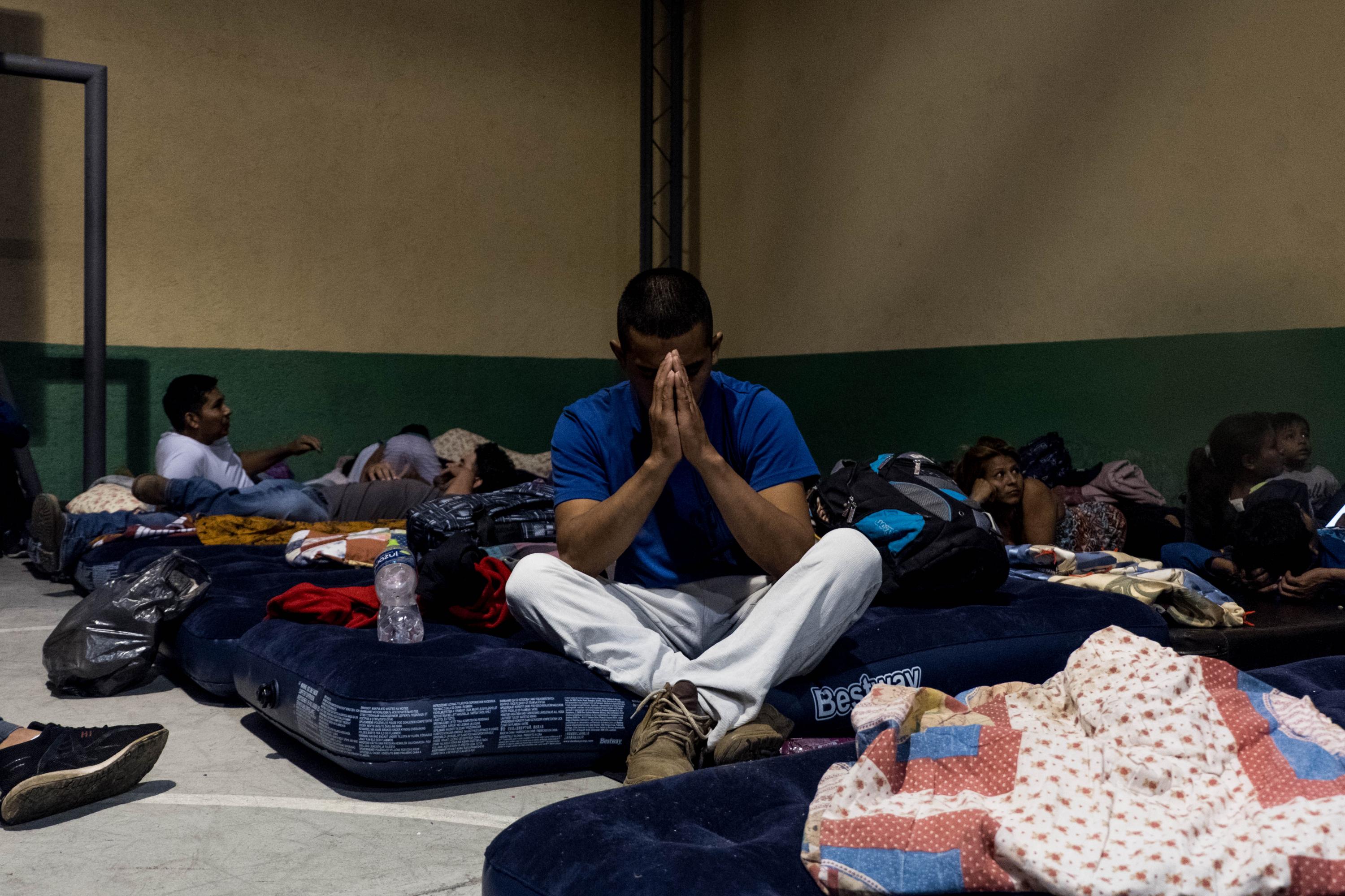 Un migrante hondureño reza antes de dormir en La Casa del Migrante en Ciudad de Guatemala, el 18 de octubre de 2018. Foto: Fred Ramos