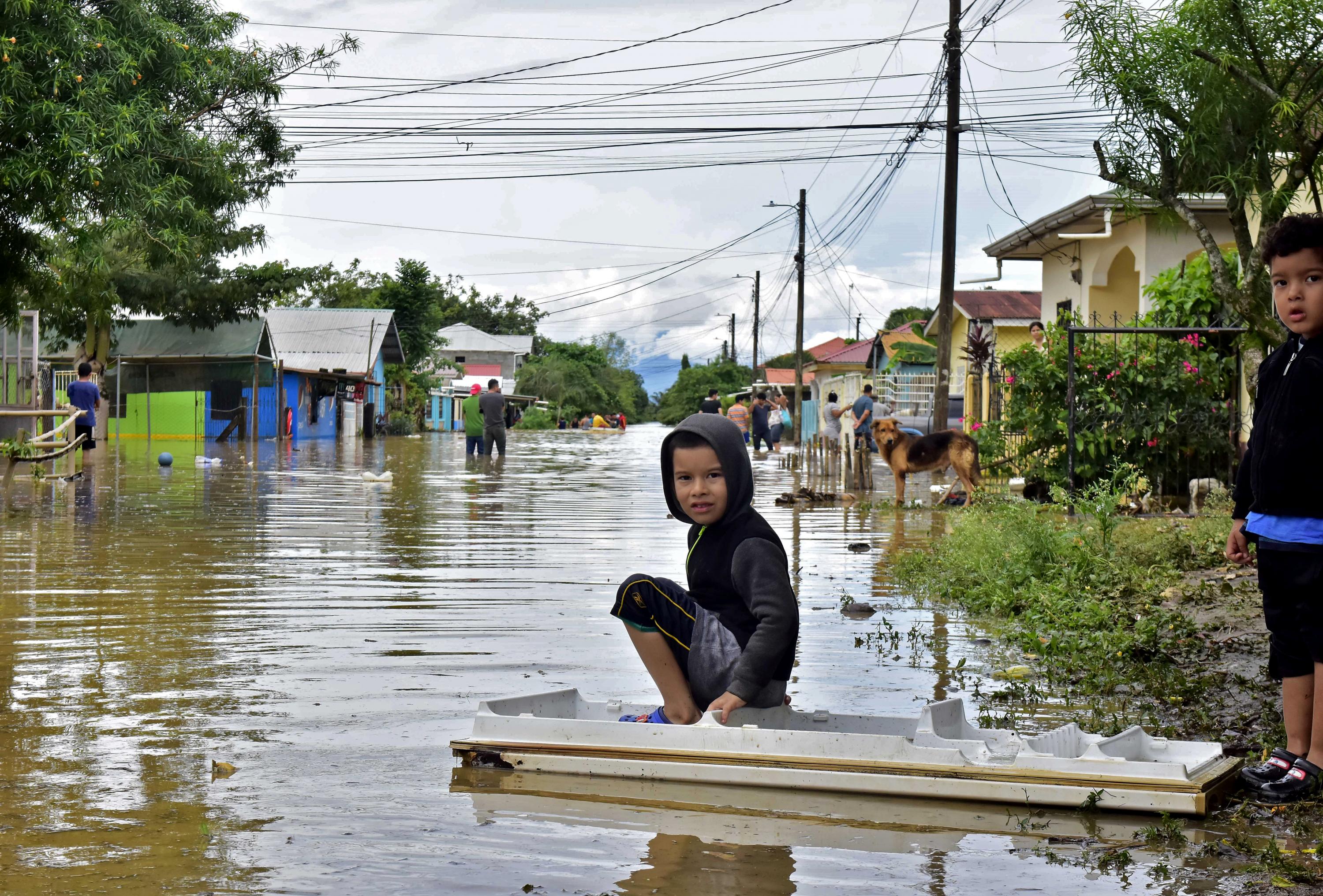 Niños juegan en una calle inundada en el barrio de Palermo en El Progreso, departamento de Yoro, Honduras. Foto de AFP.