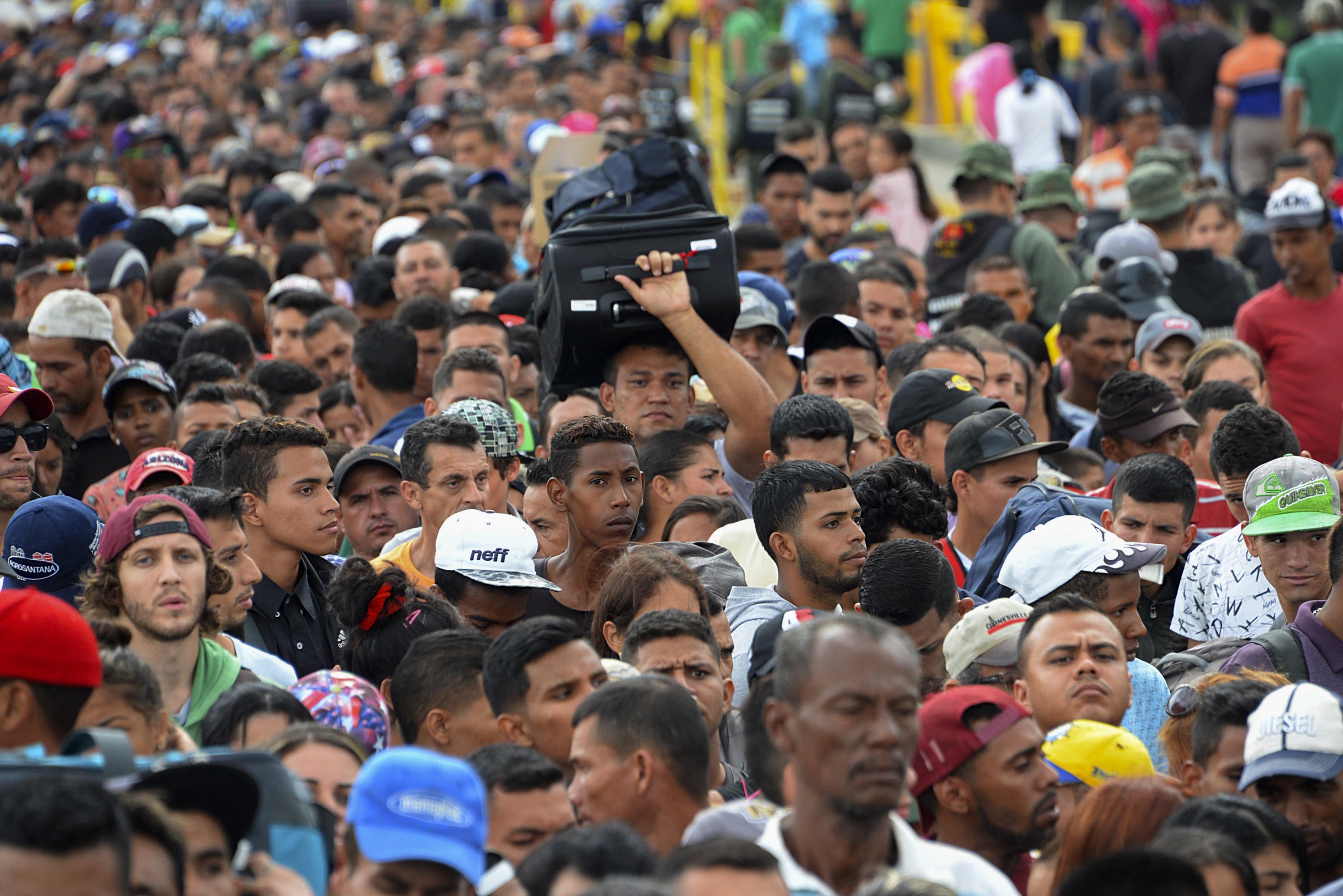 Venezuelan citizens cross the Simon Bolivar international bridge from San Antonio del Tachira in Venezuela to Norte de Santander province of Colombia on February 10, 2018. Oil-rich and once one of the wealthiest countries in Latin America, Venezuela now faces economic collapse and widespread popular protest. / AFP PHOTO / GEORGE CASTELLANOS