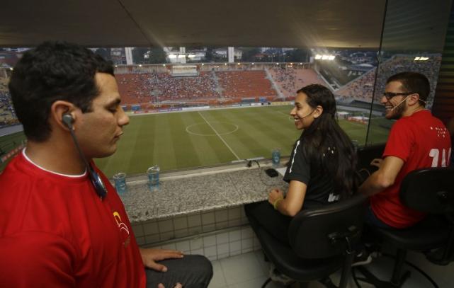 Fabricio (L) listens with a special device as Andre (R) trains to relate football matches for the blind for the upcomig Brazil 2014 FIFA World Cup, at the Pacaembu stadium in Sao Paulo, on May 21, 2014. AFP PHOTO / MIGUEL SCHINCARIOL