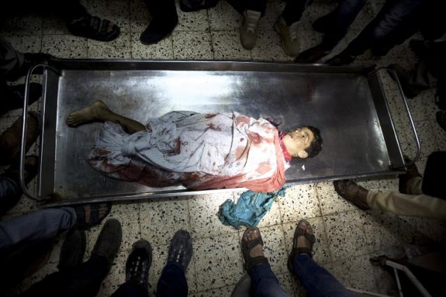 El cuerpo de uno de los cuatro niños palestinos de una misma familia masacrados por Israel mientras estaban en la playa es contemplado en la morgue del Hospital Al-Shifa, en Gaza. Foto Mahmud Hams (AFP).