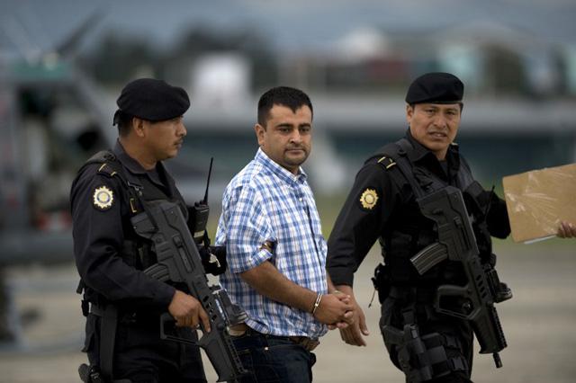 GUATEMALA, Guatemala City : Police take into custody alleged drug trafficker Walter Arelio Montejo Merida (C), aka Zope, related to the Mexican Sinaloa drug cartel, who faces an extradition warrant from the United States, upon their arrival at the air force base in Guatemala City on June 10 , 2012. AFP PHOTO Johan ORDONEZ