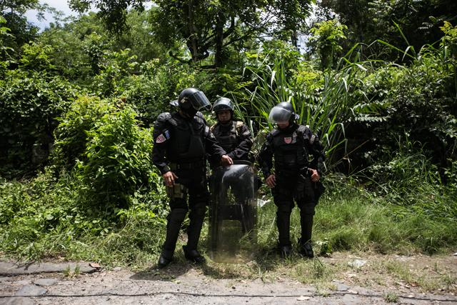 Agentes de la Unidad de Mantenimiento del Orden (UMO) de la Policía acompañan el desalojo de la comunidad El Espino, en Antiguo Cuscatlán. Explicaron que solo estaban ahí por si había disturbios pero no tenían autorizado irrumpir en los hogares. Foto: Fred Ramos