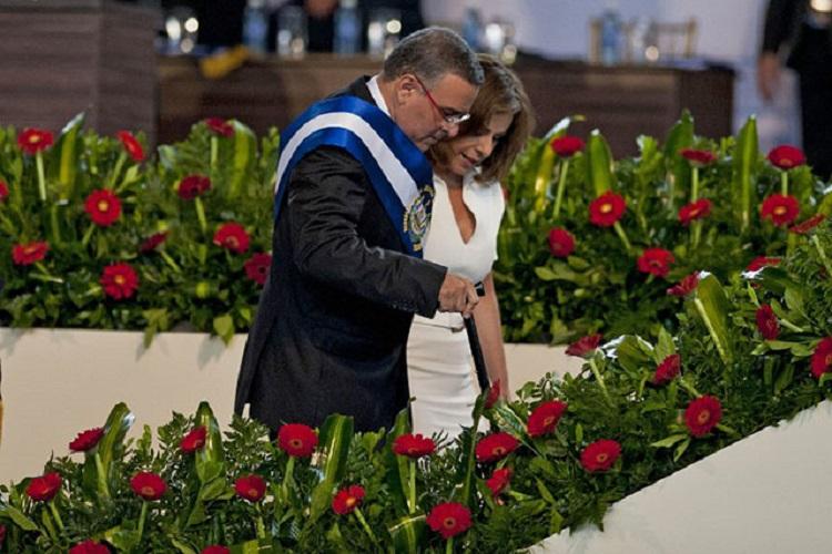 Vanda Pignato, la ex primera dama, ayuda a Mauricio Funes a subir los escalones durante el acto de traspaso de mando presidencial. 1 de junio de 2014. AFP PHOTO/ Jose CABEZAS