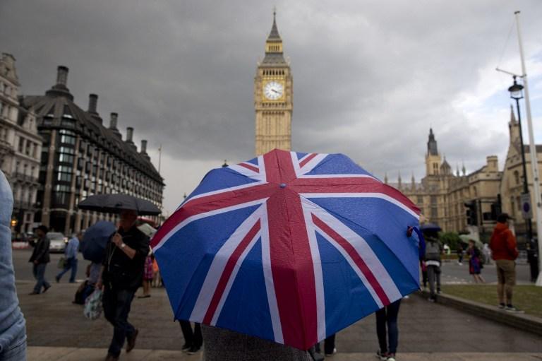 Un ciudadano londinense camina hacia el Big Ben bajo un paraguas que simula una bandera británica, pocos días después de que el Reino Unido votara por el llamado Brexit, el abandono de la Unión Europea. Foto Justin Tallis (AFP).