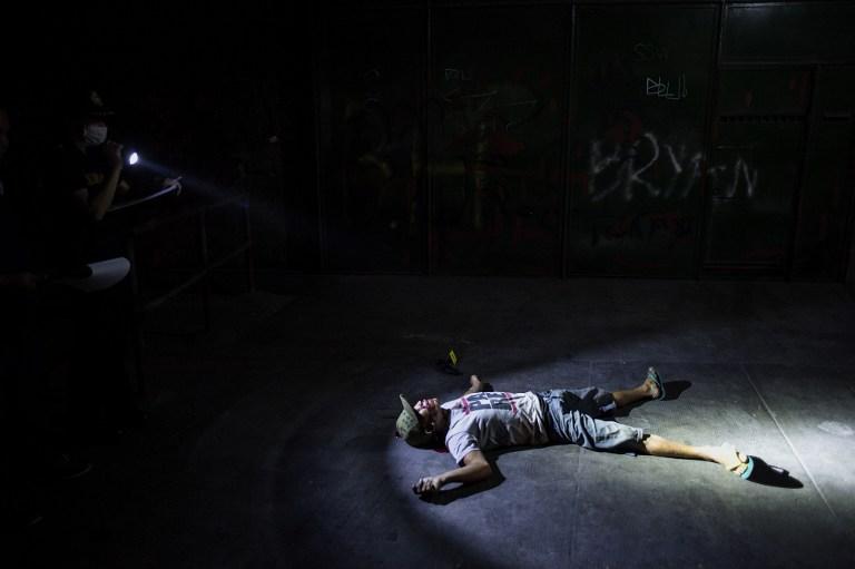 Un policía filipino procesa en una calle de la capital, Manila, la escena en la que yace inerte un presunte traficante de drogas, asesinado por desconocidos. Este tipo de homicidios se han disparado desde que asumió el presidente Rodrigo Duterte. Foto Noel Celis (AFP).
