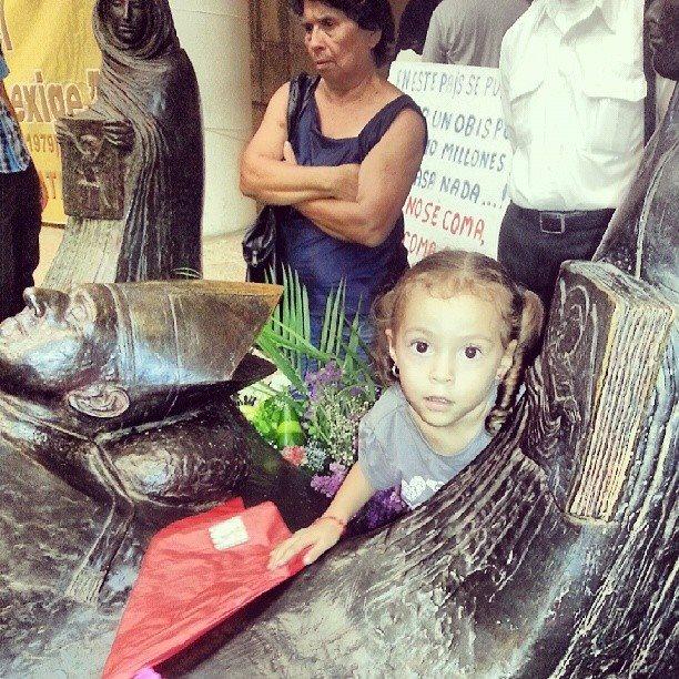 Niña juega en la tumba de Monseñor Romero.