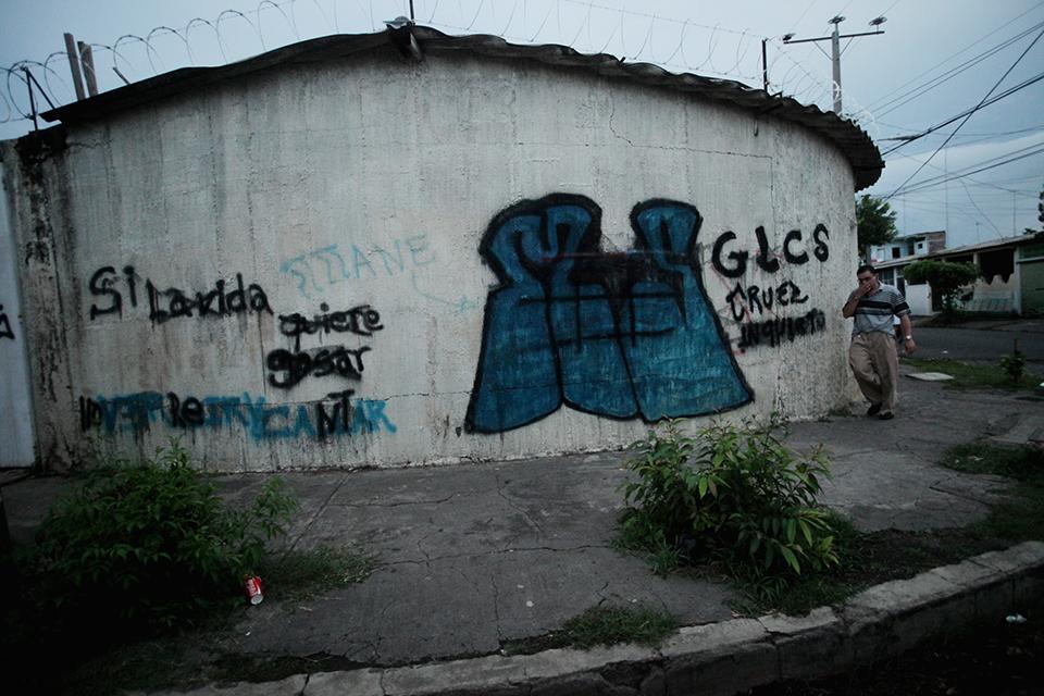 Un hombre camina frente a un placazo de la Mara Salvatrucha en el departamento de San Miguel. Foto de archivo: Mauro Arias