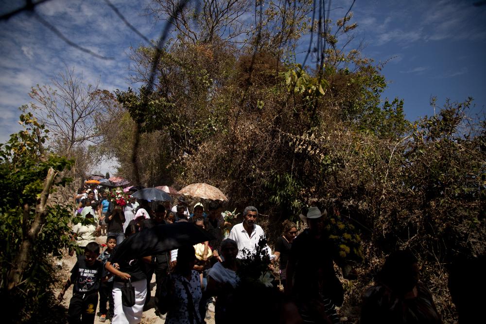 Unas 100 personas acompañaron el entierro de Misael Navas, en un cementerio rural del departamento de San Salvador. La zona donde ocurrió la ceremonia es un terreno que las pandillas se disputan. En camino al cementerio, soldados incluso revisaron a un joven que observaba a los dolientes. Foto: Víctor Peña