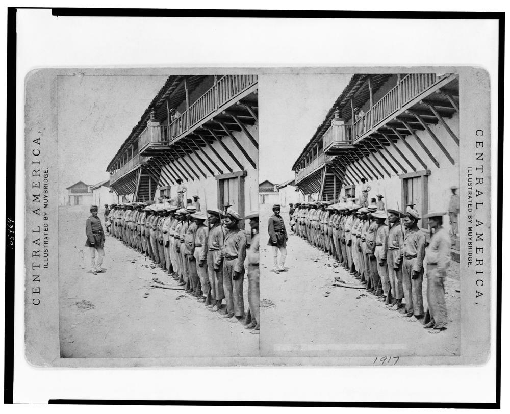 Oficial pasando lista a las milicias del ejército en el cuartel de la ciudad y Puerto de La Unión en 1875. El aumento de las exportaciones a través delos puertos dio recursos al estado para ampliar y equipar el ejército. Sin embargo, el cambio de los centros de poder económico del oriente aloccidente del país, le quitó a La Unión, la importancia económica con la que contó durante casi toda la segunda mitad del siglo XIX Fotografía estereográfica. Edweard Muybridge. Library of Congress, Stereographic Prints, 1870-1904. LOT 12068 [P&P].