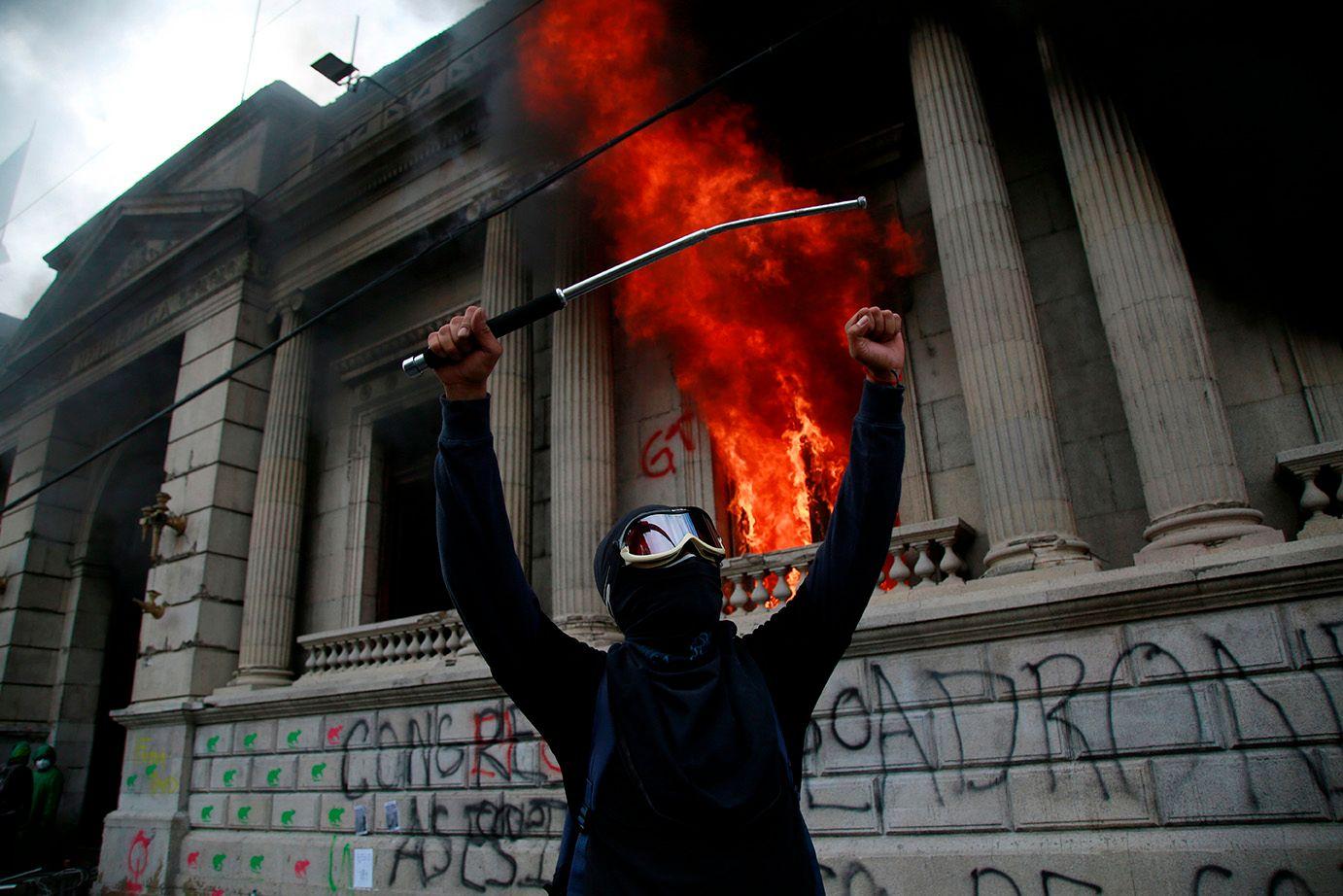A protester celebrates the burning of Congress. Esteban Biba / EFE /