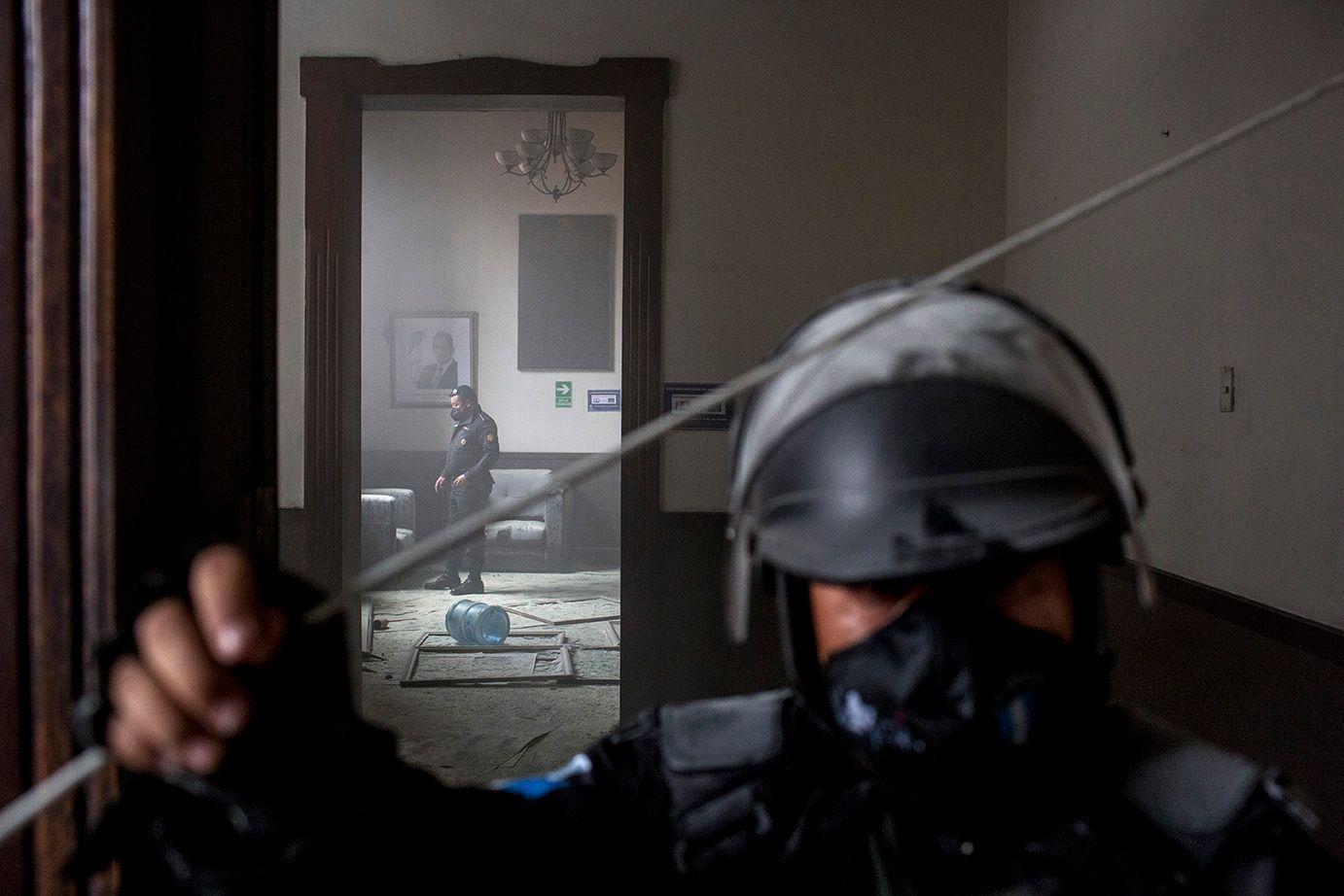 A policeman observes the burned rubble on the floor of one of the rooms damaged by the burning of Congress /