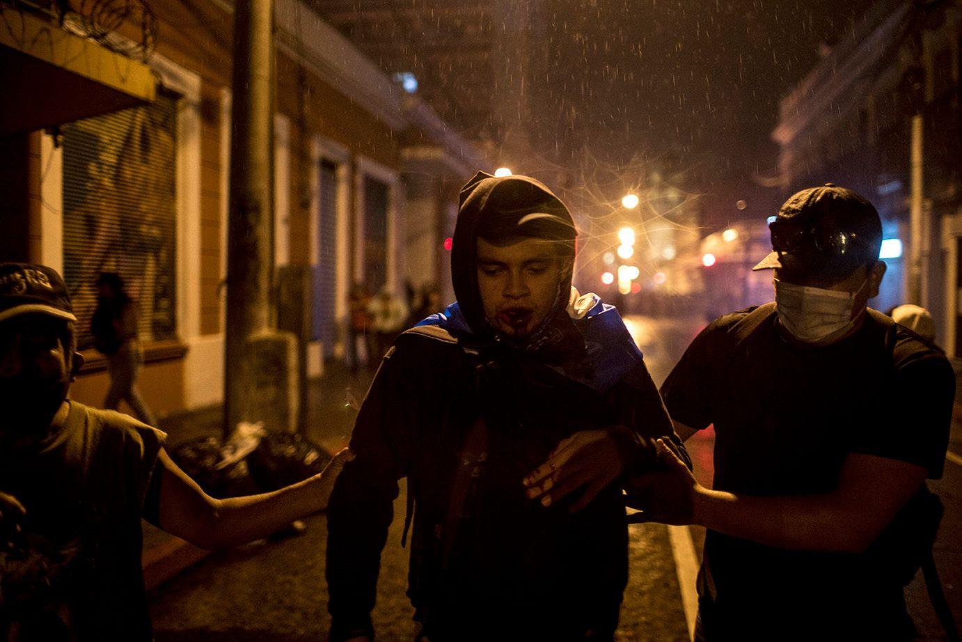 A protester is helped after being hit by tear gas /