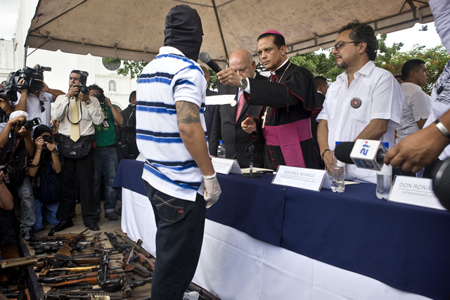 El obispo castrense Fabio Colindres ofrece el micrófono a un pandillero que declaró que la entrega de armamento es la confirmación de un proceso de pacificación de las pandillas.﻿" /></div><div class=