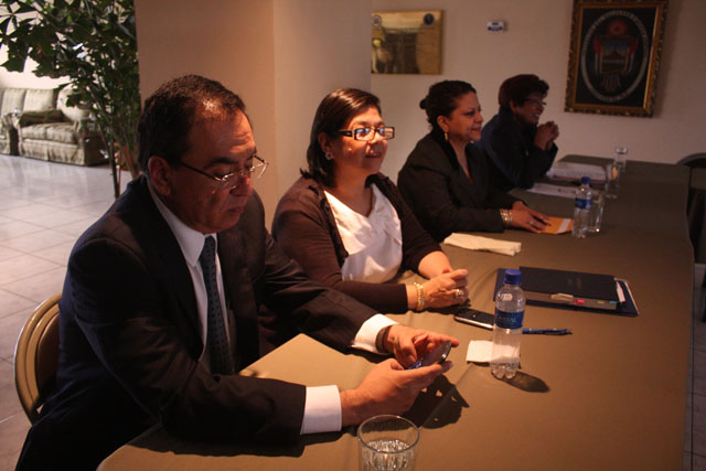 José Roberto Argueta, primero a la izquierda, observa su teléfono durante la toma de la Corte Suprema de Justicia el domingo 1 de julio 2012.