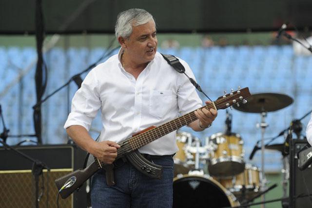 El presidente de Guetamala, el general Otto Perez Molina, se vio salpicado en el juicio por genocidio contra Efraín Ríos Montt que fue anulado en 2013 por orden de la Corte de Constitucionalidad. En esta imagen, toca la escopetarra en un concierto contra la violencia en abril de 2013. Foto Johan Ordóñez (AFP)