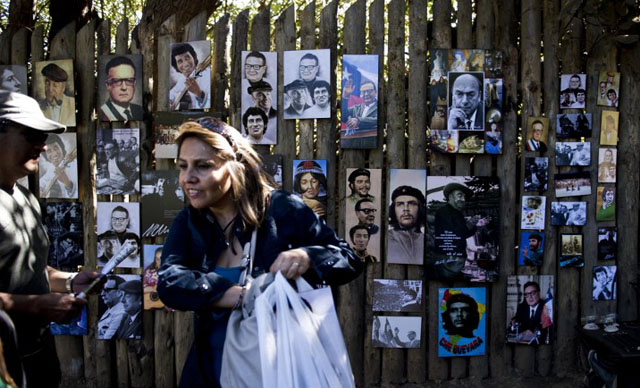 Turistas observan fotos de Pablo Neruda, Salvador Allende, Ernesto 