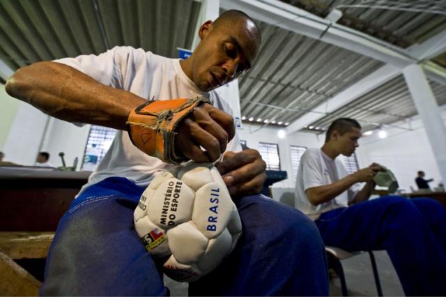 Un interno del centro penal Nilton Silva, en el estado de Sao Paulo, fabrica una pelota de fútbol en el marco del programa Pintando la libertad, que el Ministerio de Deportes ejecuta en 90 cárceles.﻿ Foto Nelson Almeida (AFP)﻿.
