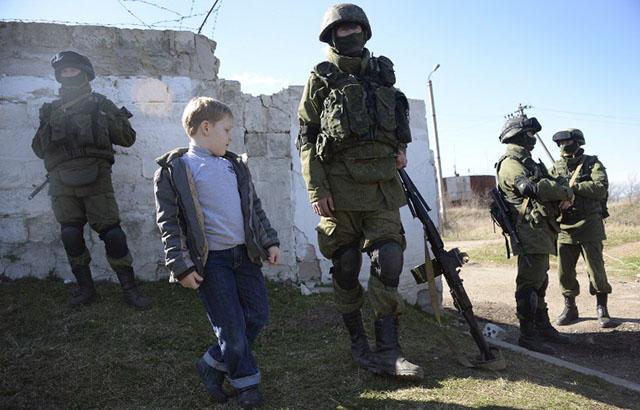 Un grupo de paramilitares fuertemente armados hace guardia fuera de una base militar ucrania ubicada en Perelvane, en Crimea, la península que se disputan Ucrania y Rusia.﻿ Foto Alexander Nemenov (AFP)﻿.