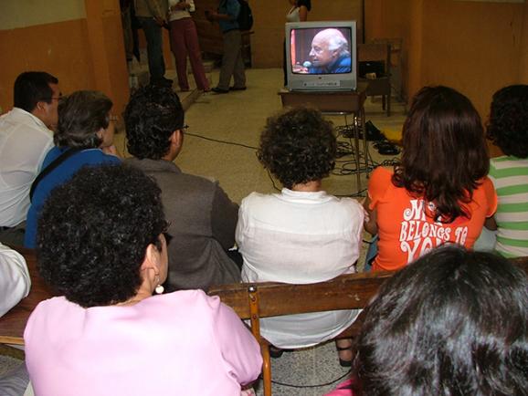 El día cuando la Universidad de El Salvador hizo el reconocimiento a Eduargo Galeano, en octubre de 2005, el Teatro Universitario fue insuficiente para todo el público que quiso presenciar la ceremonia y escuchar el discurso del escritor, así que hubo quienes afuera de la sala lograron atestiguar el acta por medio de pantallas de televisor. / Foto por cortesía de la Secretaría de Comunicaciones de la Universidad de El Salvador.
