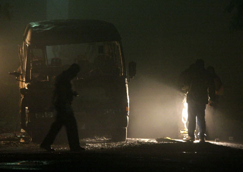 Agentes policiales recolectan evidencias en el microbús de la ruta 47 en el cual murieron 14 pasajeros baleados y calcinados.