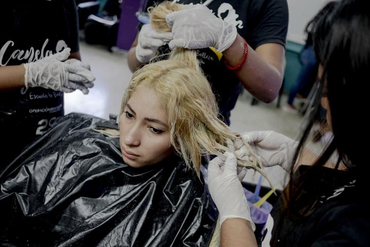 Marisol Amador durante su clase de tratamientos de belleza en el centro de San Pedro Sula, Honduras. Tiene 19 años, es hondureña y fue deportada desde Chiapas, México, en mayo de este año. Migró hacia Estados Unidos porque no encontraba trabajo, pero fue detenida por agentes de migración en Tapachula, Chiapas. Desde hace cinco meses asiste a este curso junto a otras veinte mujeres jóvenes que reciben apoyo de la ONG Operación Bendición. Tres de sus compañeras también han sido deportadas. Foto: Fred Ramos.
