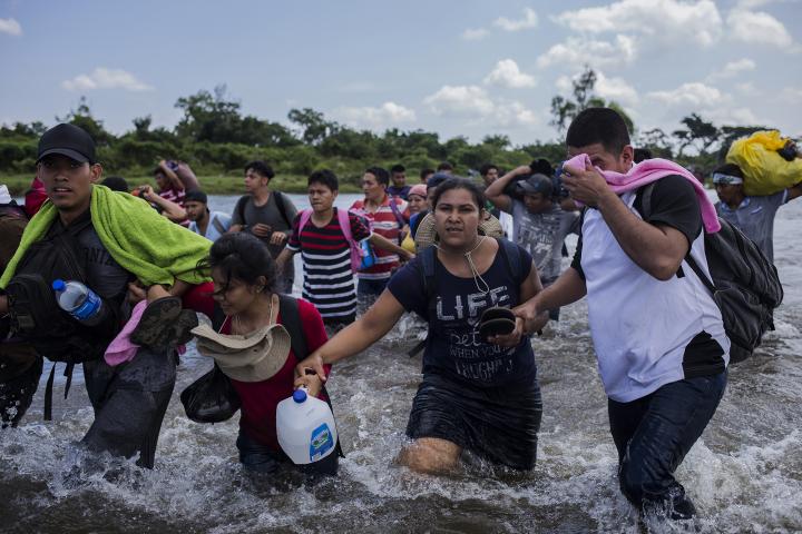 El 2 de noviembre de 2018 una de las caravanas, que había salido de San Salvador tres días antes, cruzó el río Suchiate y puso pies en México. Antes, sus cerca de tres mil integrantes habían esperado durante casi cuatro horas en el puente Rodolfo Robles, que conecta Tecún Umán (Guatemala) y Ciudad Hidalgo (México), donde las autoridades mexicanas trataron de convencerlos de que se registraran para tener un ingreso ordenado. El grupo dudó de las promesas oficiales, discutió a gritos, empujó, y terminó por lanzarse al río para cruzar la línea imaginaria que separa Guatemala de México. Los pocos cientos que aceptaron registrarse en el puesto migratorio fueron deportados a sus países de origen semanas después. Cruzar a la brava el Suchiate fue la primera gran victoria de esa caravana. Pese al cansancio, se celebró como si el poder del grupo les hiciera invencibles y la meta estuviera más cerca. Aunque después se disolvió, la caravana llegó unida el 12 de noviembre de 2018 a Ciudad de México. Foto: Víctor Peña.