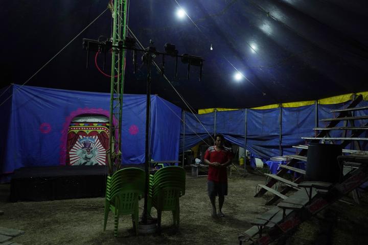 Rigoberto, de 53 años, prepara el escenario para la función. Es empleado del circo Majestic, que se instaló en la urbanización Las Margaritas, en Soyapango. Algunas veces pagaron hasta $300 por instalarse en un lugar controlado por pandillas. "Legalmente ellos eran la autoridad. Ahora las cosas han cambiado y ya no se trabaja con ese temor", dice Rigoberto. El circo no ha pagado extorsión esta vez. Foto de El Faro: Víctor Peña.