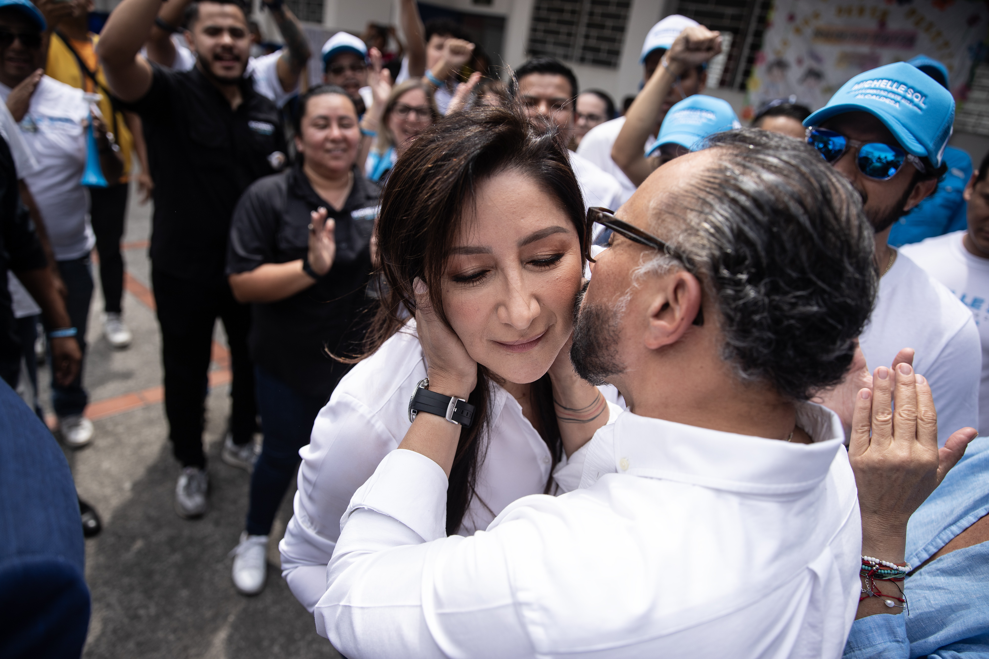 El Presidente de la Asamblea Legislativa, Ernesto Castro, besó a su esposa Michelle Sol después de que la candidata a alcaldesa por la Libertad Este votará en el Centro Escolar Pedro Pablo Castillo de Nuevo Cuscatlán. Cerca de la 7:00 pm, Milagro Navas anunció que había ganado en todas las juntas receptoras de votos de dicho centro de votación. Foto de El Faro: Carlos Barrera.