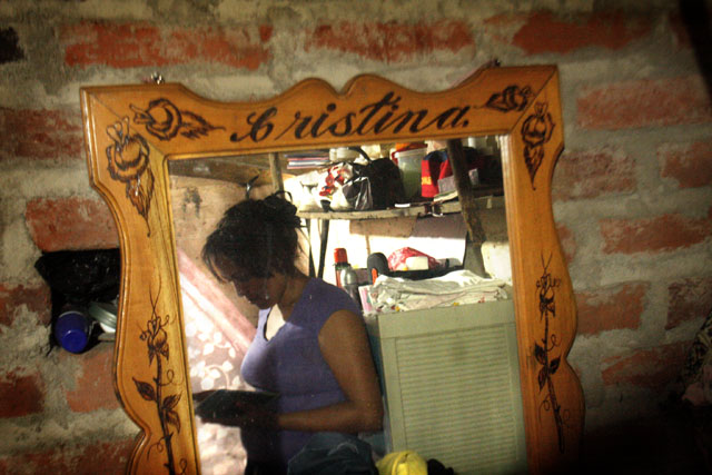Cristina Quintanilla en su cuarto, observa un albúm de fotos de la familia. Foto Frederick Meza