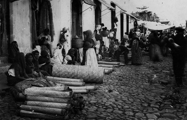 Fotografía tomada por el antropólogo Carl V. Hartmann en la plaza de Nahuizalco en 1887. Este fue uno de los primeros intentos de Hartmann por fotografiar a los indígenas, ya que se rehusaban a ser retratados por temor a que la cámara les robara el alma.﻿ / Foto MUPI.