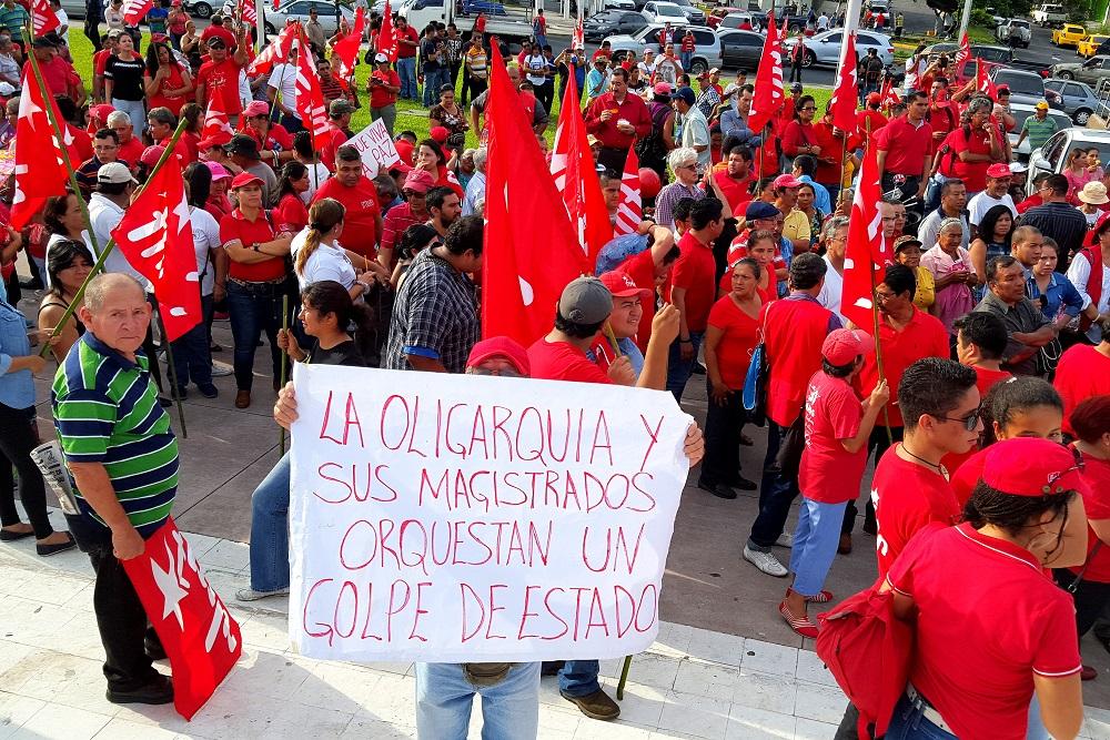 Un simpatizante del FMLN muestra una pancarta contra la Sala de lo Constitucional en un mitin partidario celebrado en San Salvador, apenas unos días después de que una sentencia de esa institución declare inconstitucional la Ley de Amnistía de 1993. Foto Nelson Rauda Zablah.