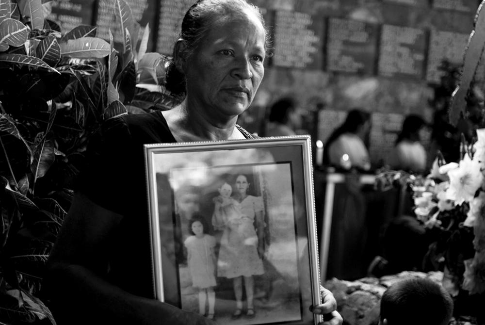 Miriam Núñez, esposa de Orlando Márquez, sostiene una fotografía tomada unos meses antes de la masacre en la que están retratadas su suegra María Agustina García y sus cuñadas Edith Elizabeth Márquez y Yesenia Márquez. Todas ellas fueron asesinadas por el batallón Atlacátl. 