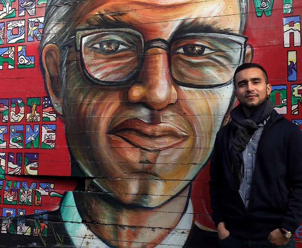 Javier Zamora, poeta salvadoreño, junto a un mural con el rostro de Monseñor Romero. Foto cortesía de Javier Zamora.