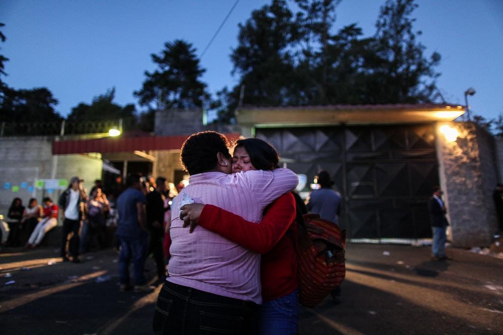 Dos familiares se abrazan afuera del Hogar Seguro el 8 de marzo de 2017. Foto de Nómada: Carlos Sebastián
