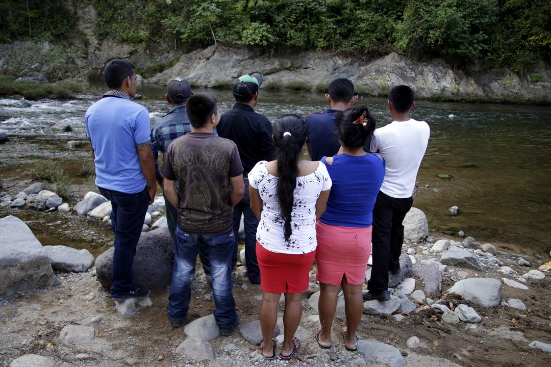 Community leaders pose with their backs turned in front of the San Pedro River. Defending natural resources in the Aguán Valley provokes political and legal persecution. Many land defenders are nervous about being identified by the police. Photo: Martín Cálix