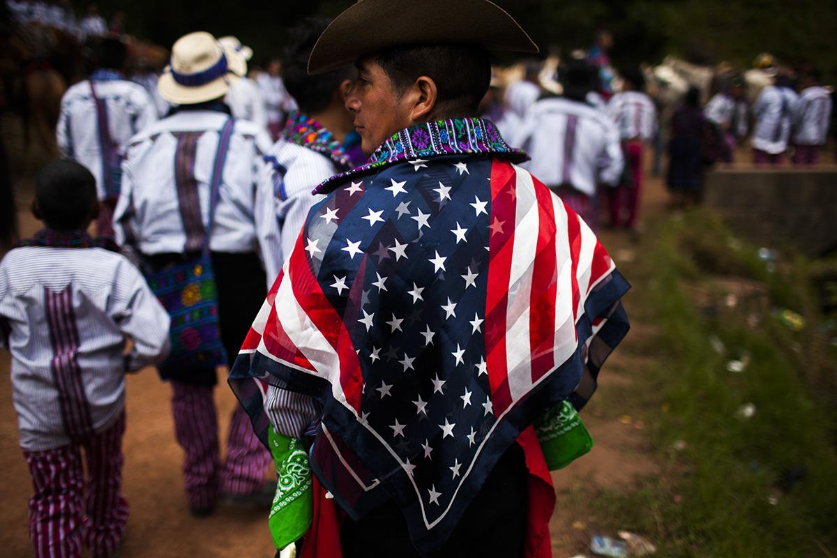 A resident of Todos Santos Cuchumatán wears a U.S. flag on his shoulders during a community festival on November 1, 2017. Photo: Simone Dalmasso
