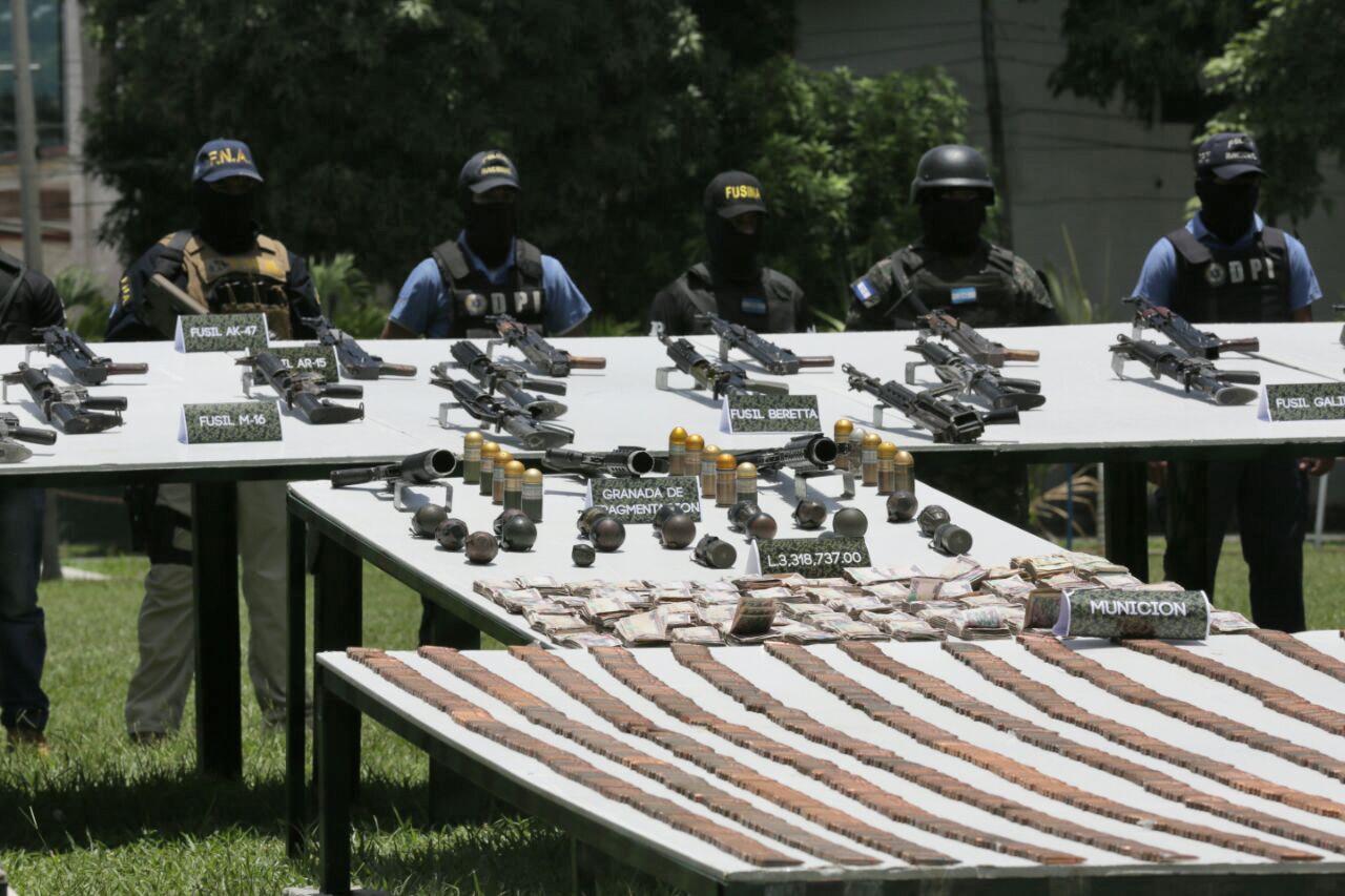 La Policía Nacional de Honduras presenta armas y municiones incautadas supuestamente a clicas de la MS-13 y del Barrio 18 en San Pedro Sula. Foto AFP.
