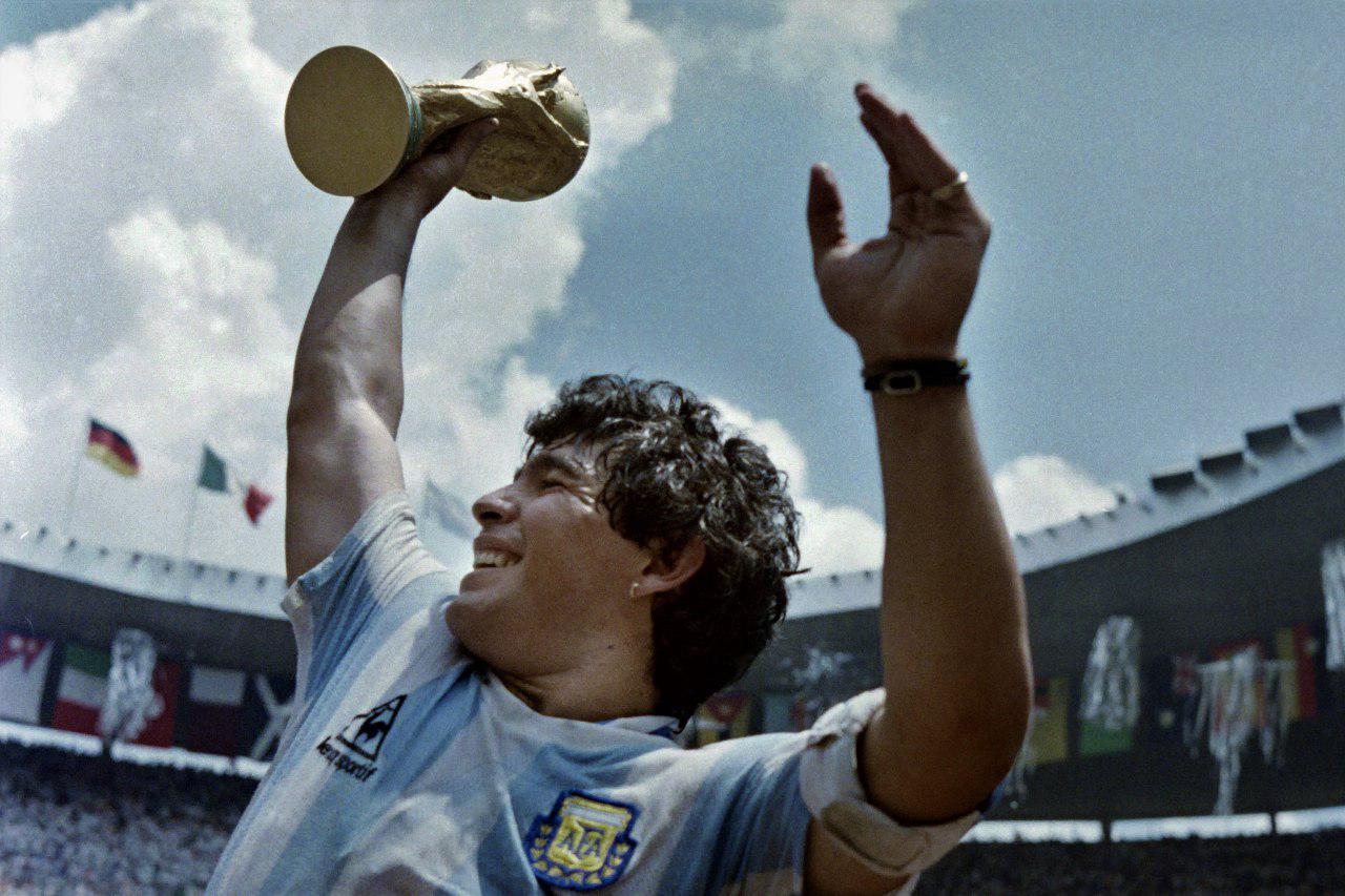 Diego Armando Maradona carga el trofeo en México 1986, el mundial en el que se convirtió en astro del fútbol y marcó un gol con la mano a los ingleses. Foto AFP.