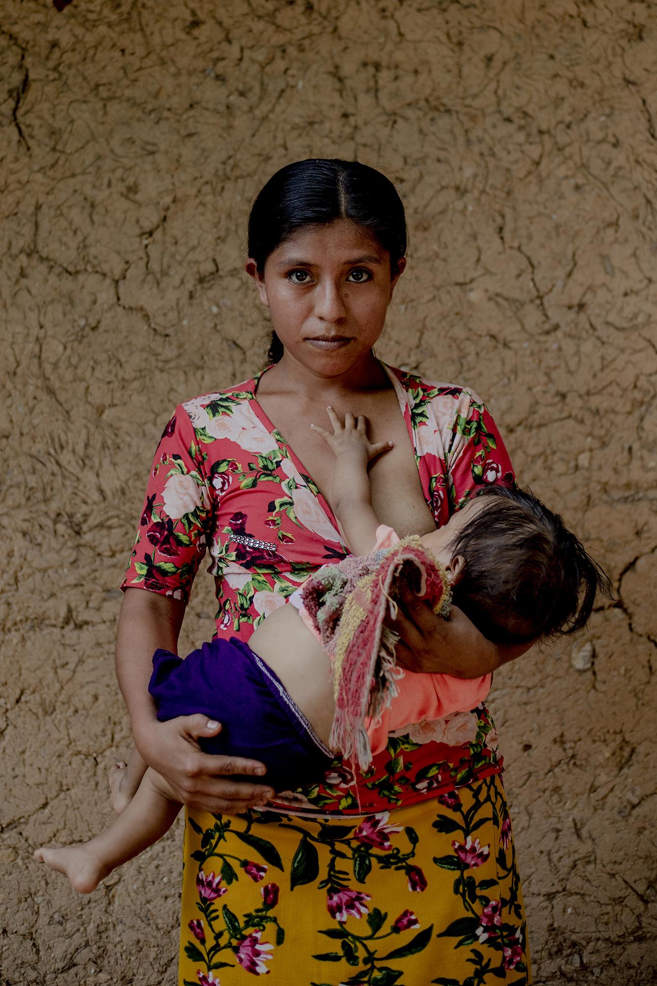 María García tiene 23 años. Posa con su hijo de once meses, al que han diagnosticado desnutrición en la clínica de Camotán. “Me han dicho que debo darle vitaminas”, dice. También quisiera irse a México, o a Estados Unidos, pero dice que es demasiado pobre para migrar. Foto: Fred Ramos.