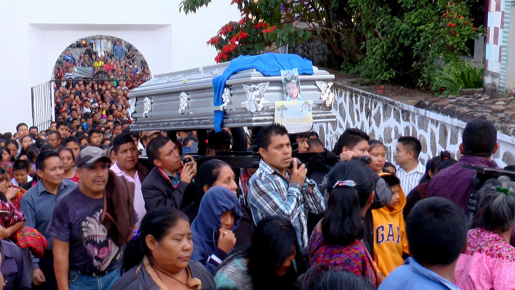 Un grupo de hombres carga el ataúd con el cuerpo del niño Absalón, en la entrada al cementerio municipal de Chichicastenango. El entierro tuvo lugar el 20 de octubre de 2017 y fue multitudinario. Foto cortesía Canal 4 Chichi.