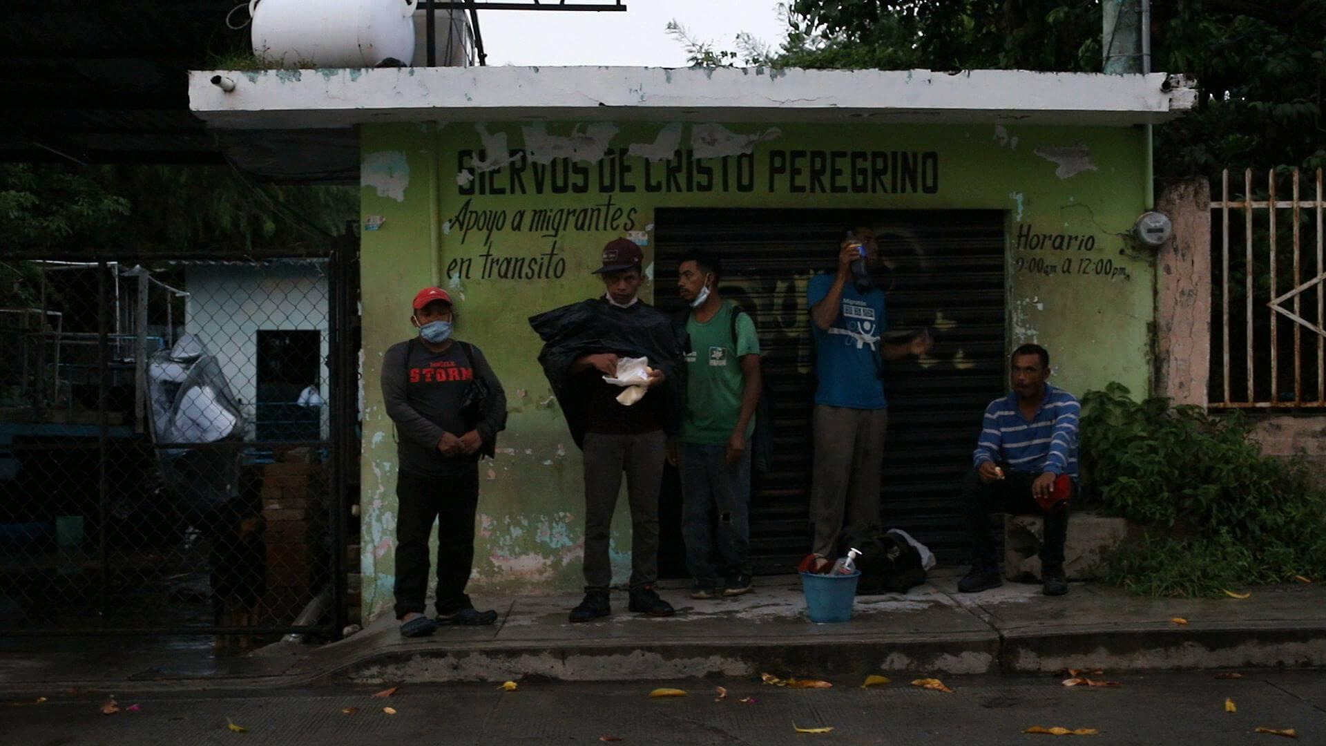 A group of migrants takes shelter from the rain in Tierra Blanca as they wait for the northbound train. / Javier García