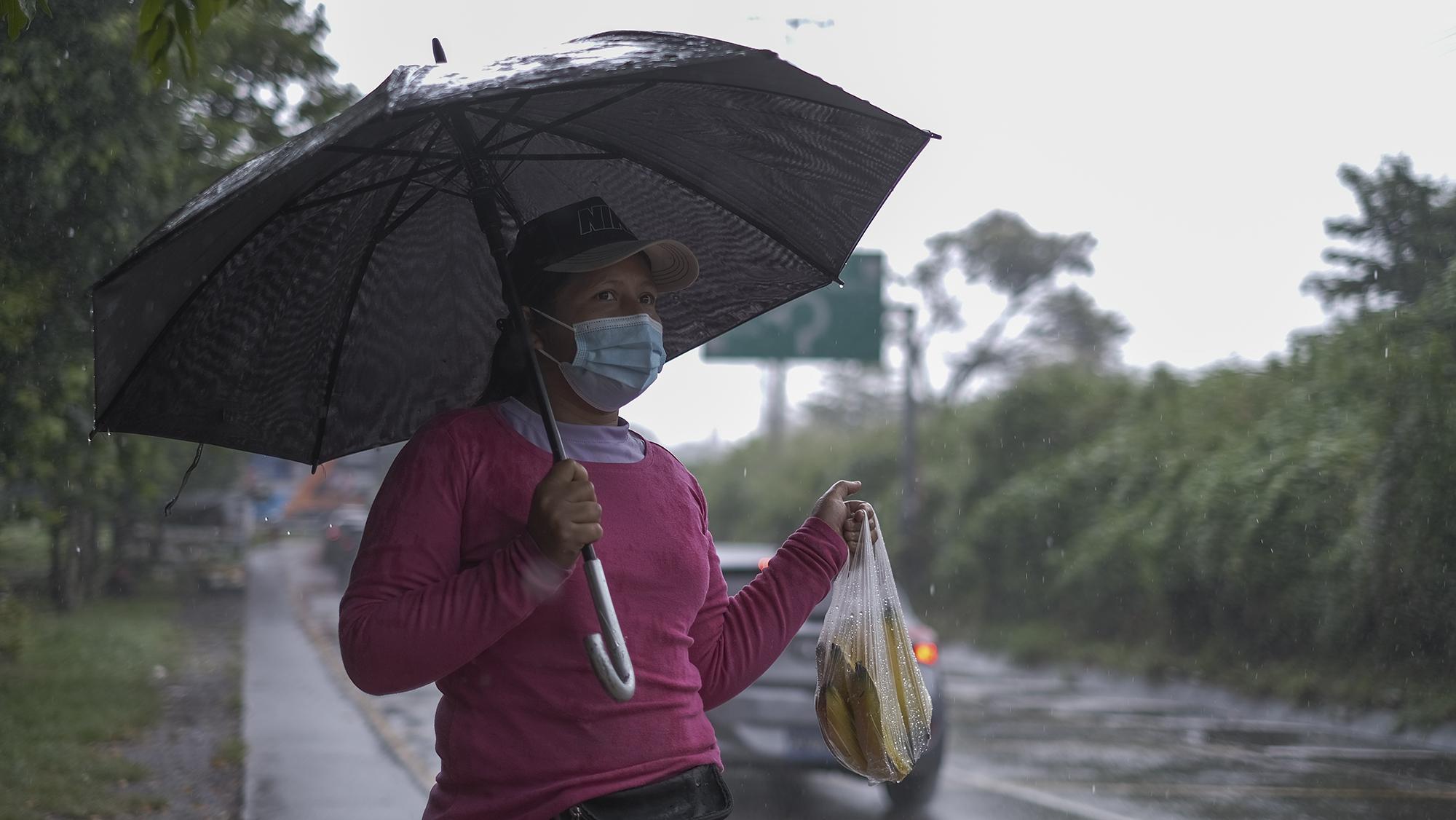 Ana Colindres de 33 años vende guineos durante una tormenta consecuencia de la entrada de Eta en Centroamérica. Ana lleva dos años vendiendo en el mismo lugar junto a Mirna Mazariego quien le provee de las frutas para poder generar ingresos para su familia.