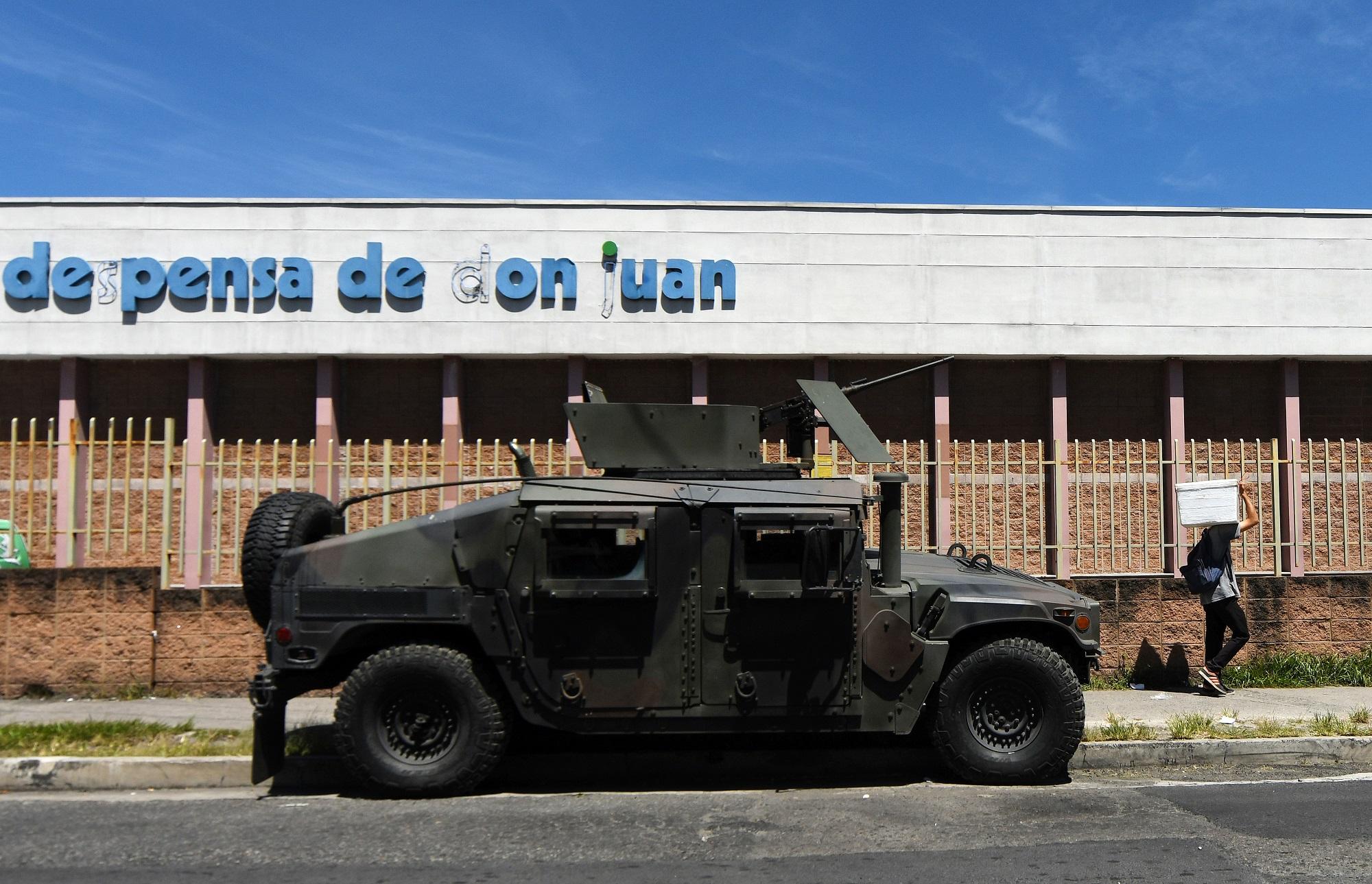Un Humvee de la Fuerza Armada de El Salvador permanece estacionado frente a un supermercado ubicado en el bulevar de Los Héroes, en la capital. Desde mediados de septiembre, el gabinete de seguridad ha colocado vehículos militares en las principales plazas y arterias de San Salvador. Foto Marvin Recinos (AFP).