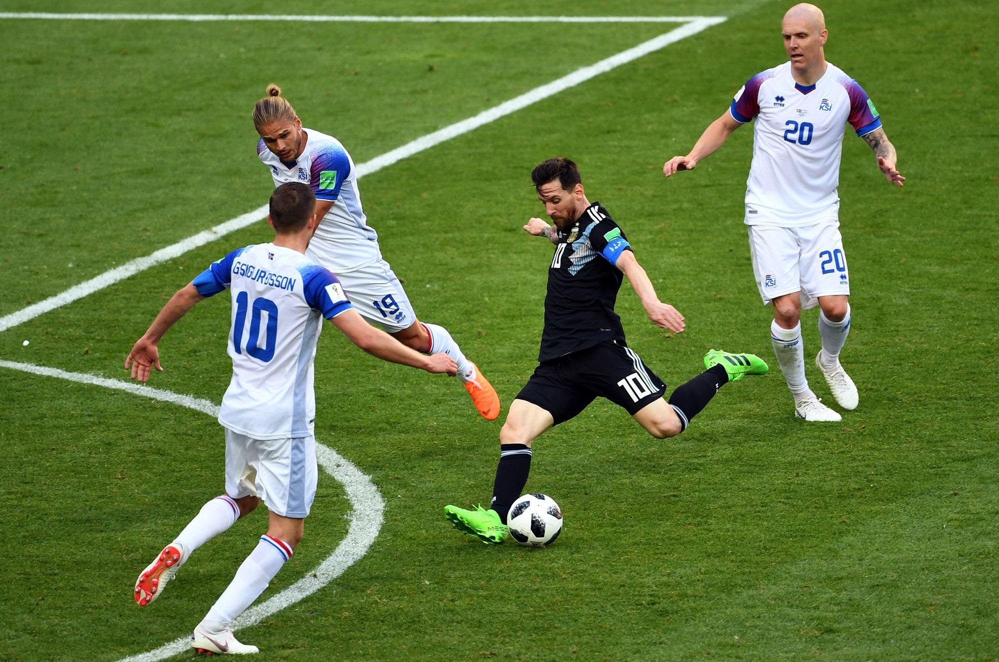 Lionel Messi dispara al borde del área rodeado por tres defensores islandeses. Argentina e Islandia se midieron este 16 de junio, partido que terminó en empate, 1 a 1.  Foto Wang Yuguo (Xinhua).