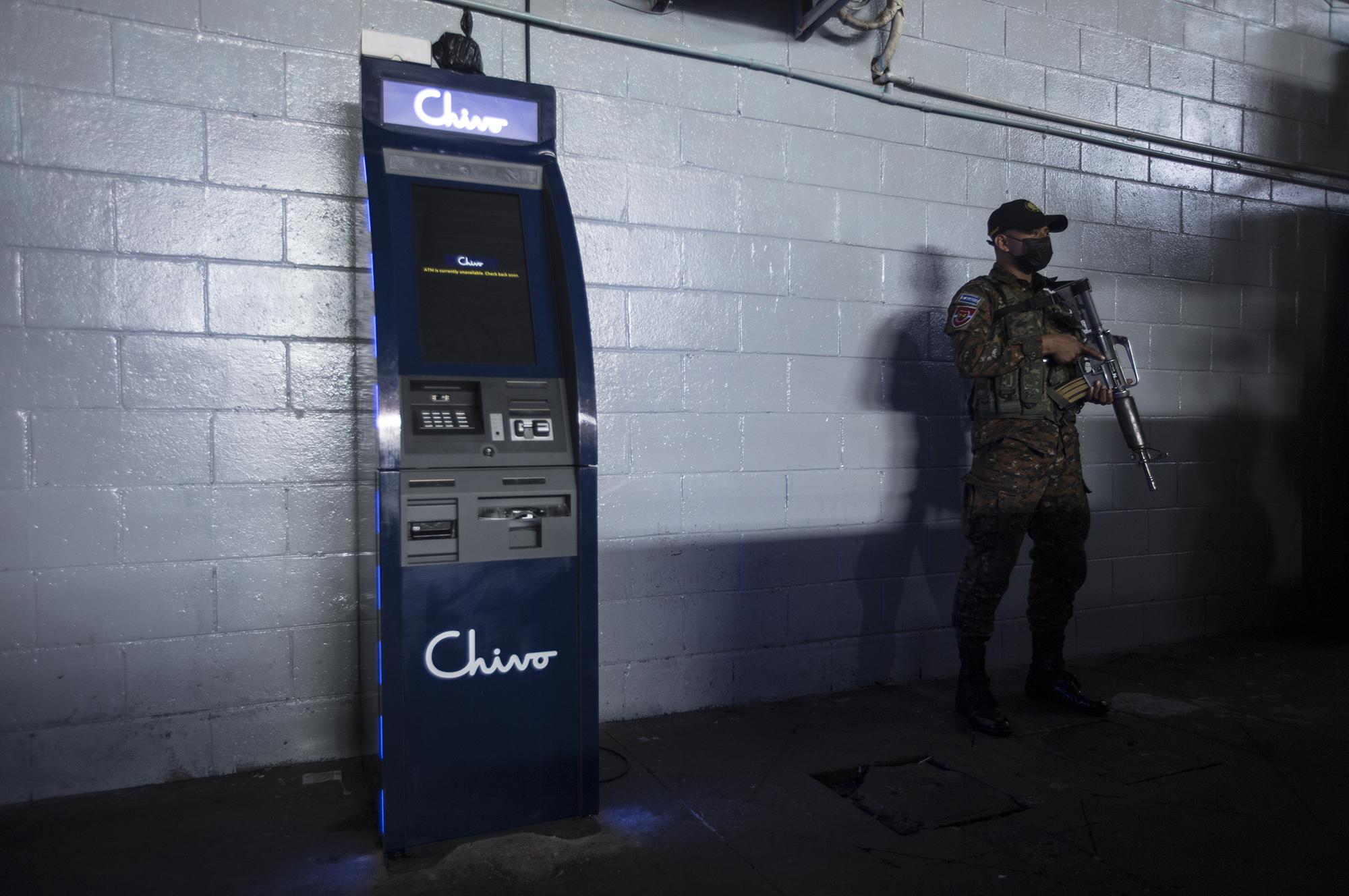 A Salvadoran soldier stands watch over a government bitcoin ATM in Santa Tecla, La Libertad. Photo: Víctor Peña/El Faro