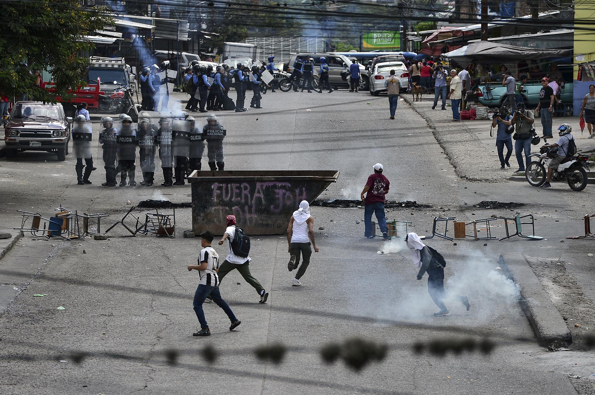 La policía antidisturbios hondureña se enfrenta a los manifestantes que exigen la renuncia del presidente Juan Orlando Hernández por sus presuntos vínculos con el narcotráfico. Tegucigalpa, 21 de octubre de 2019. Foto por Orlando Sierra / AFP.