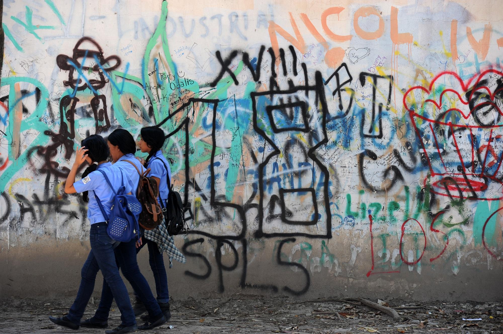 Students await to take classes at the Instituto Saul Zelaya high school in Tegucigalpa, on April 27, 2016. The Instituto Zelaya is under the control of the Mara 18 juvenile gang. Both the Mara 18 and the Mara Salvatrucha (MS-19) gangs try to recruit students in their intent to control the drug trafficking in Tegucigalpa. / AFP PHOTO / ORLANDO SIERRA