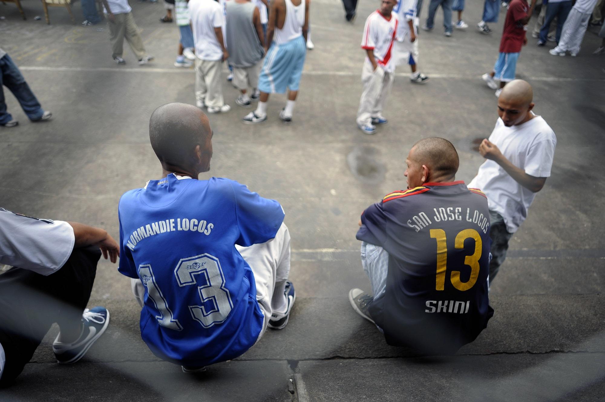 Dos pandilleros de la MS-13 conversan en el patio de la cárcel de Ciudad Barrios, en San Miguel. Cada uno lleva una camisola con el nombre de su clica y el número 13 que los identifica como pandilla sureña. Foto José Cabezas (AFP).