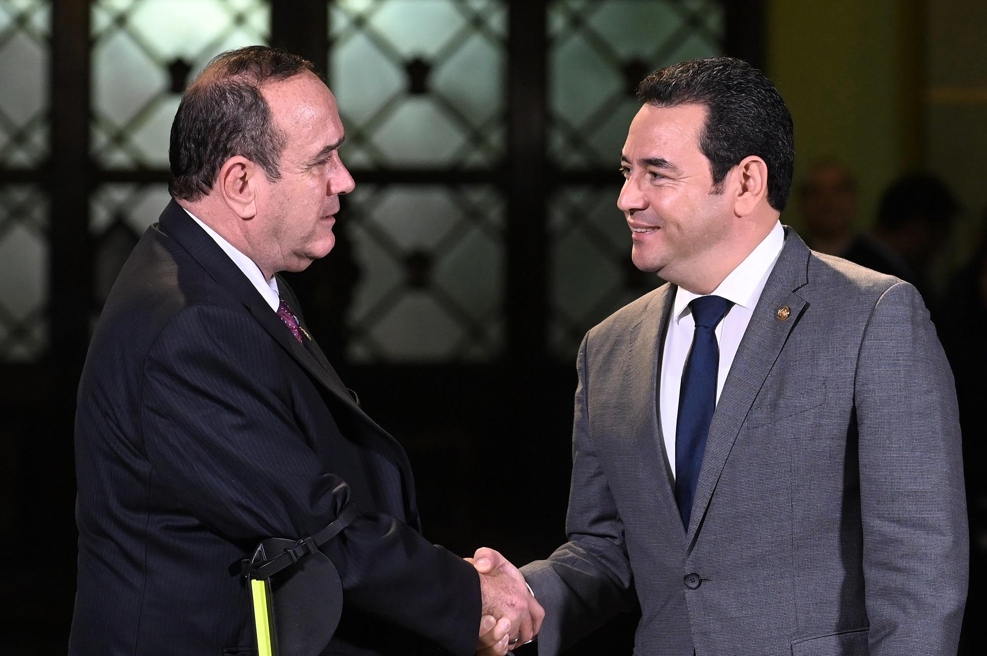 Photo caption: Former Guatemalan president Jimmy Morales (right) greets his successor, Alejandro Giammattei Falla, after a joint conference in the Palace of Culture in Guatemala city on August 14, 2019, three days after the presidential elections. As Giammattei took office on January 14, 2020, he voiced criticism of the Morales administration. Photo by Johan Ordóñez/AFP.
